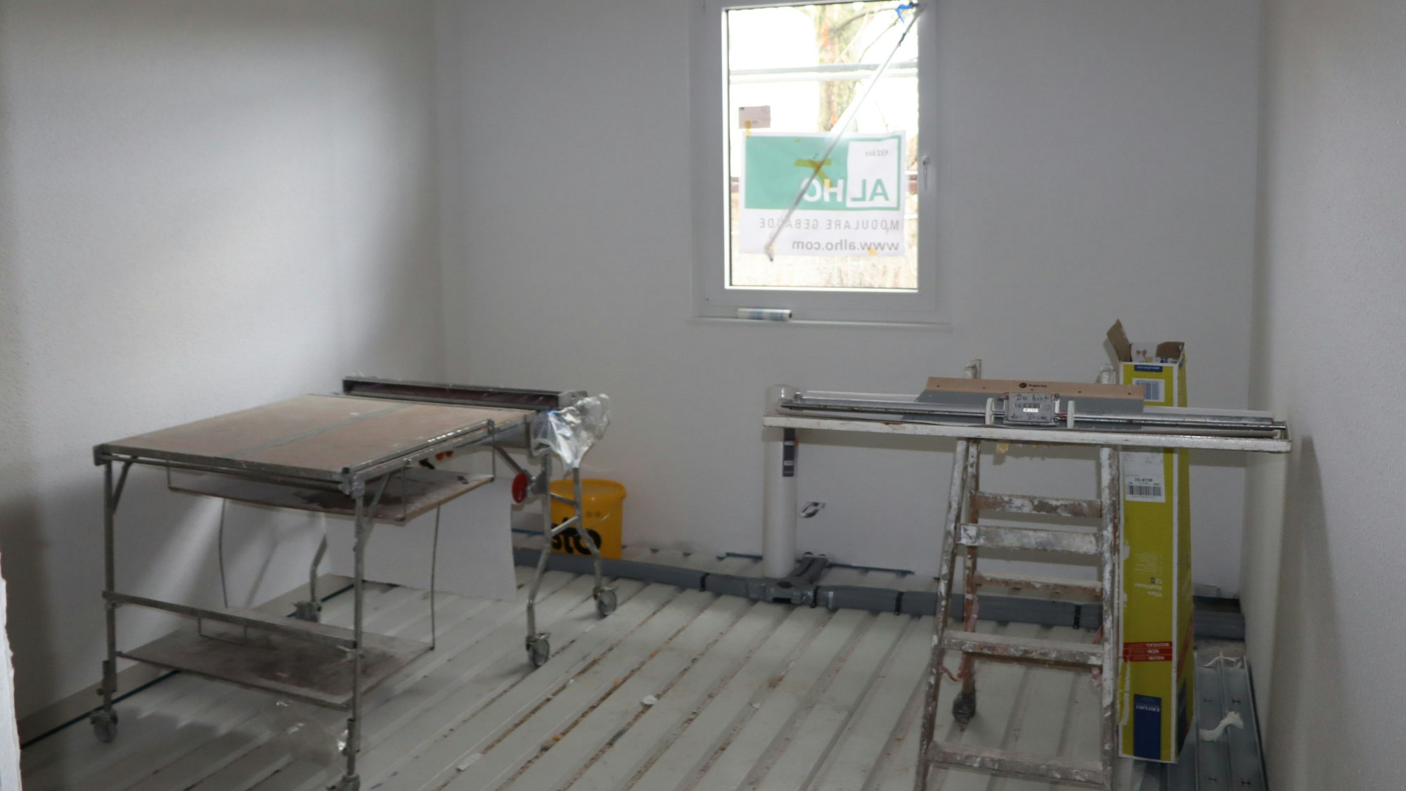 Das Foto zeigt eine Wohnunterkunft für Geflüchtete von innen. Nach dem Tapezieren in den bereits fertig monierten Wohneinheiten kann der Estrich in den nächsten Tagen gelegt werden.