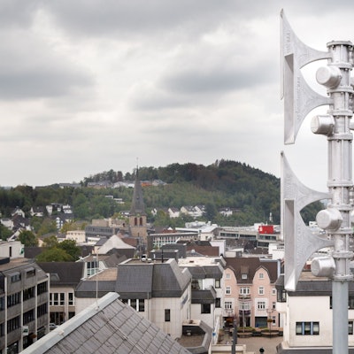 Eine silberne Warnsirene ist auf einem Dach befestigt.