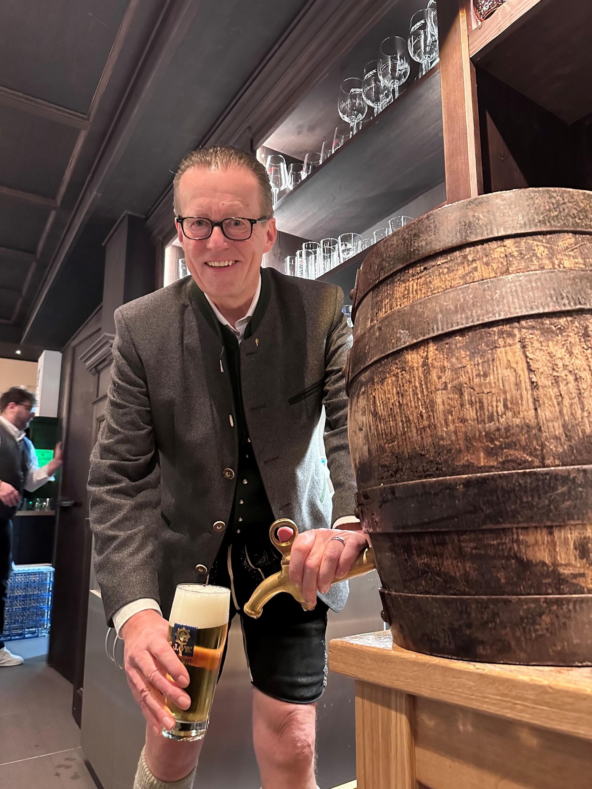 Brauerei-Chef Martin Leibhard zapft ein Bier vom Fass. Er trägt Lederhosen.