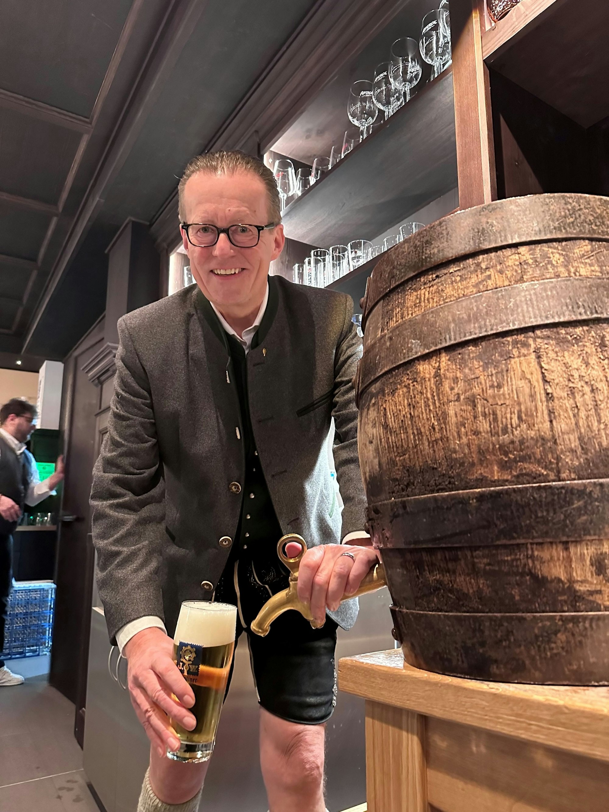 Brauerei-Chef Martin Leibhard zapft ein Bier vom Fass. Er trägt Lederhosen.