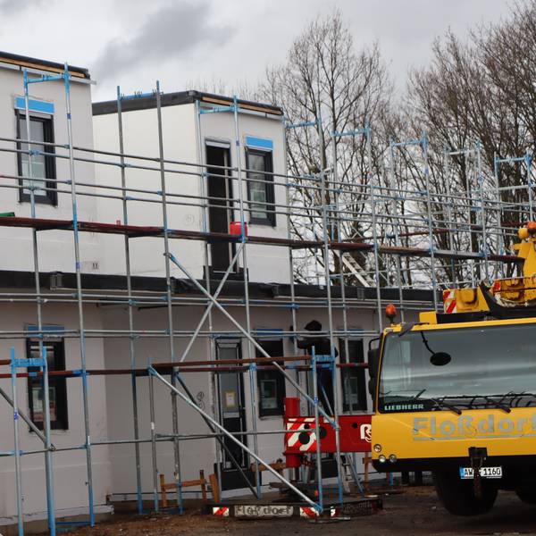 Das Foto zeigt den Fortgang der Bauarbeiten in Erftstadt: Wie Legosteine werden die Wohnmodule nebeneinander und aufeinander gesetzt. Dann beginnt auch direkt der Innenausbau.