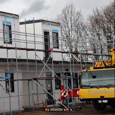 Das Foto zeigt den Fortgang der Bauarbeiten in Erftstadt: Wie Legosteine werden die Wohnmodule nebeneinander und aufeinander gesetzt. Dann beginnt auch direkt der Innenausbau.