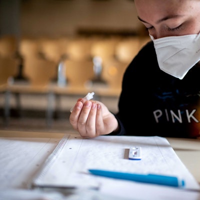 Eine Schülerin mit FFP2-Maske führt einen Coronatest durch.