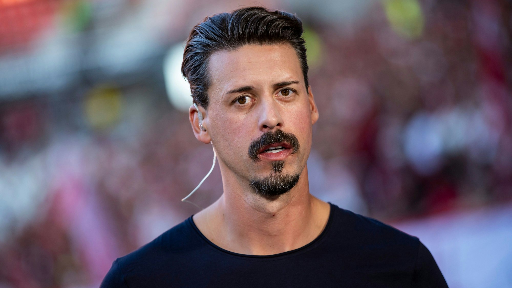 TV-Experte Sandro Wagner steht im Freiburger Stadion und schaut in die Kamera.