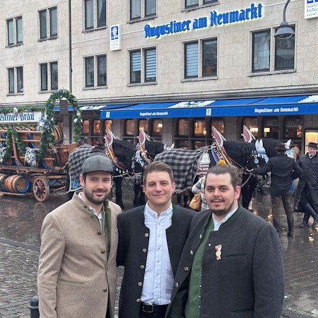 Die Geschäftsführer des bayerischen Brauhauses Augustiner am Heumarkt, Janis Leiro Nogueira, Tobias Sudowe und Lasse Prumbaum stehen vor dem Augustiner-Brauhaus am Heumarkt. Hinter ihnen eine Kutsche.