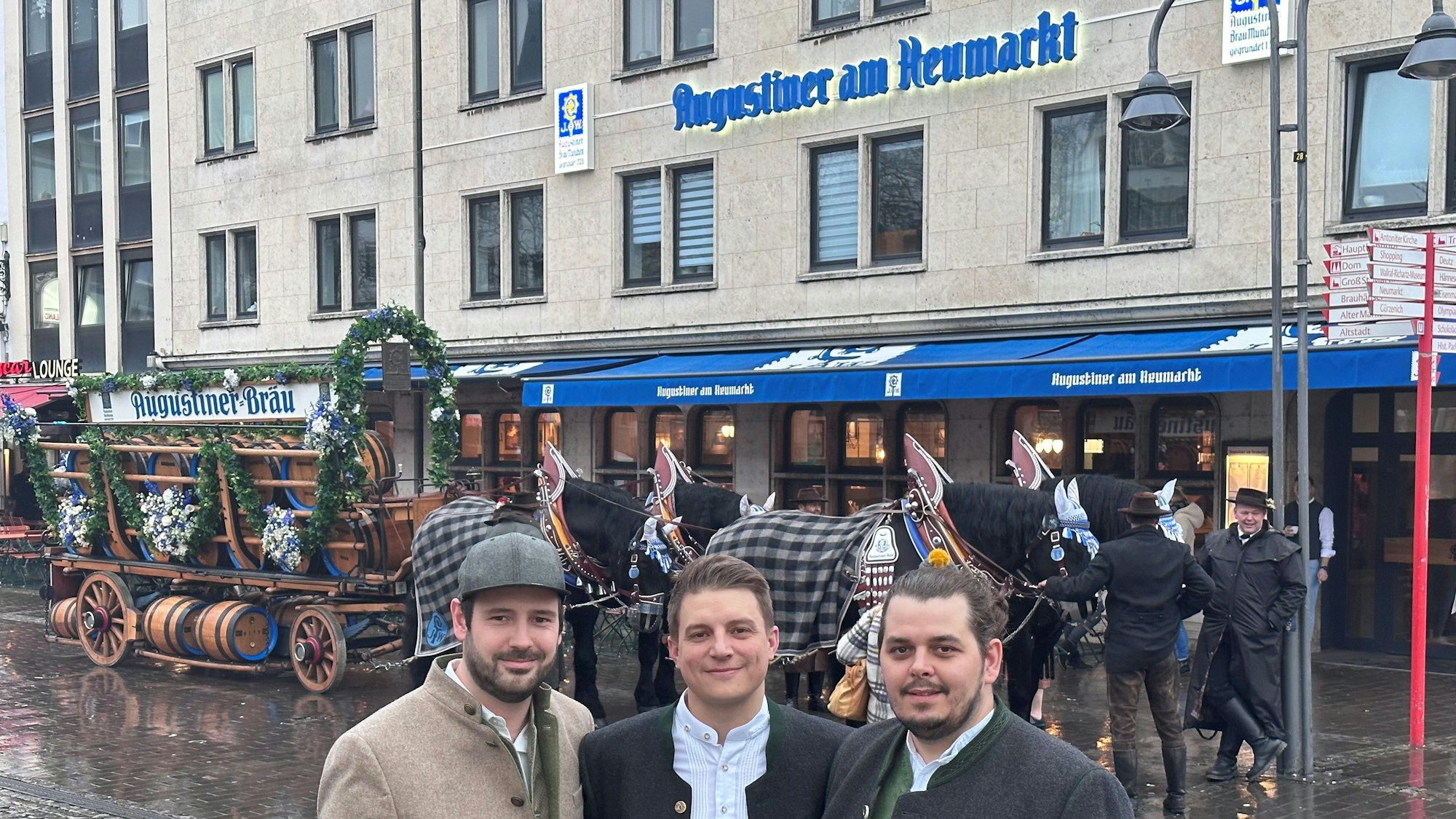 Die Geschäftsführer des bayerischen Brauhauses Augustiner am Heumarkt, Janis Leiro Nogueira, Tobias Sudowe und Lasse Prumbaum stehen vor dem Augustiner-Brauhaus am Heumarkt. Hinter ihnen eine Kutsche.