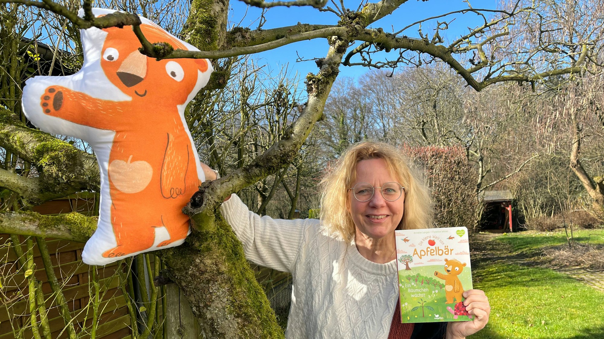 Annette Langen mit dem Apfelbär an ihrem eigenen Apfelbaum