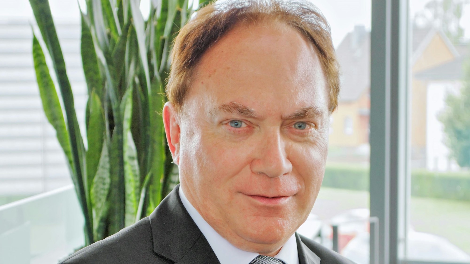 Hans-Walter Borries, Experte für den Schutz kritischer Infrastruktur, trägt einen Anzug und guckt in die Kamera.