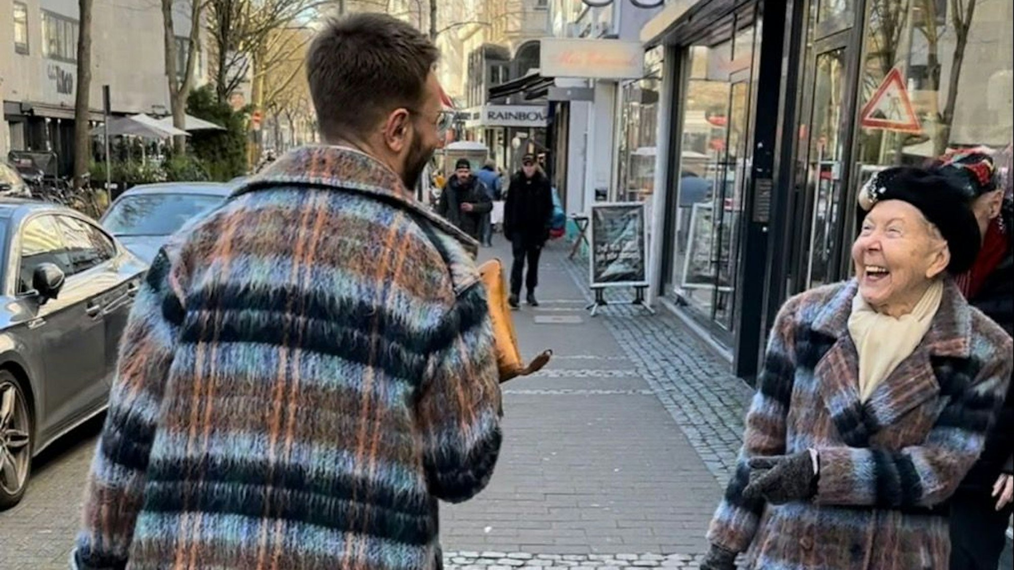 Renate Springer lacht als sie Dustin Clauß sieht, den man nur von hinten erkennt.