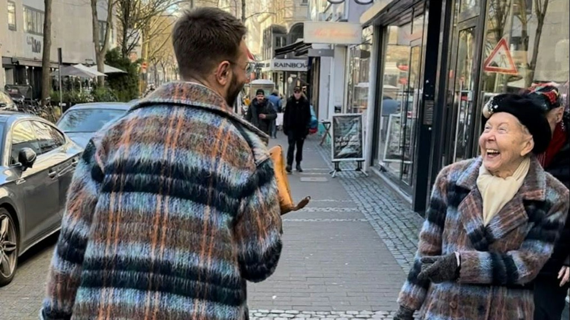 Renate Springer lacht als sie Dustin Clauß sieht, den man nur von hinten erkennt.