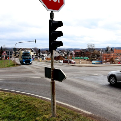 Ein Auto wartet an einer Kreuzung, dass es links abbiegen kann