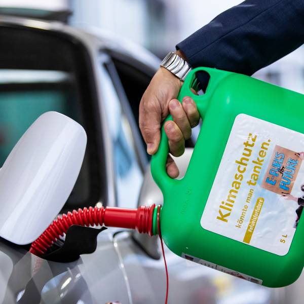 Ein Auto wird mit einem Kanister mit der Aufschrift «Klimaschutz könnte man Tanken - E-Fules for Future» an einer Tankstelle mit E-Fuel betankt.