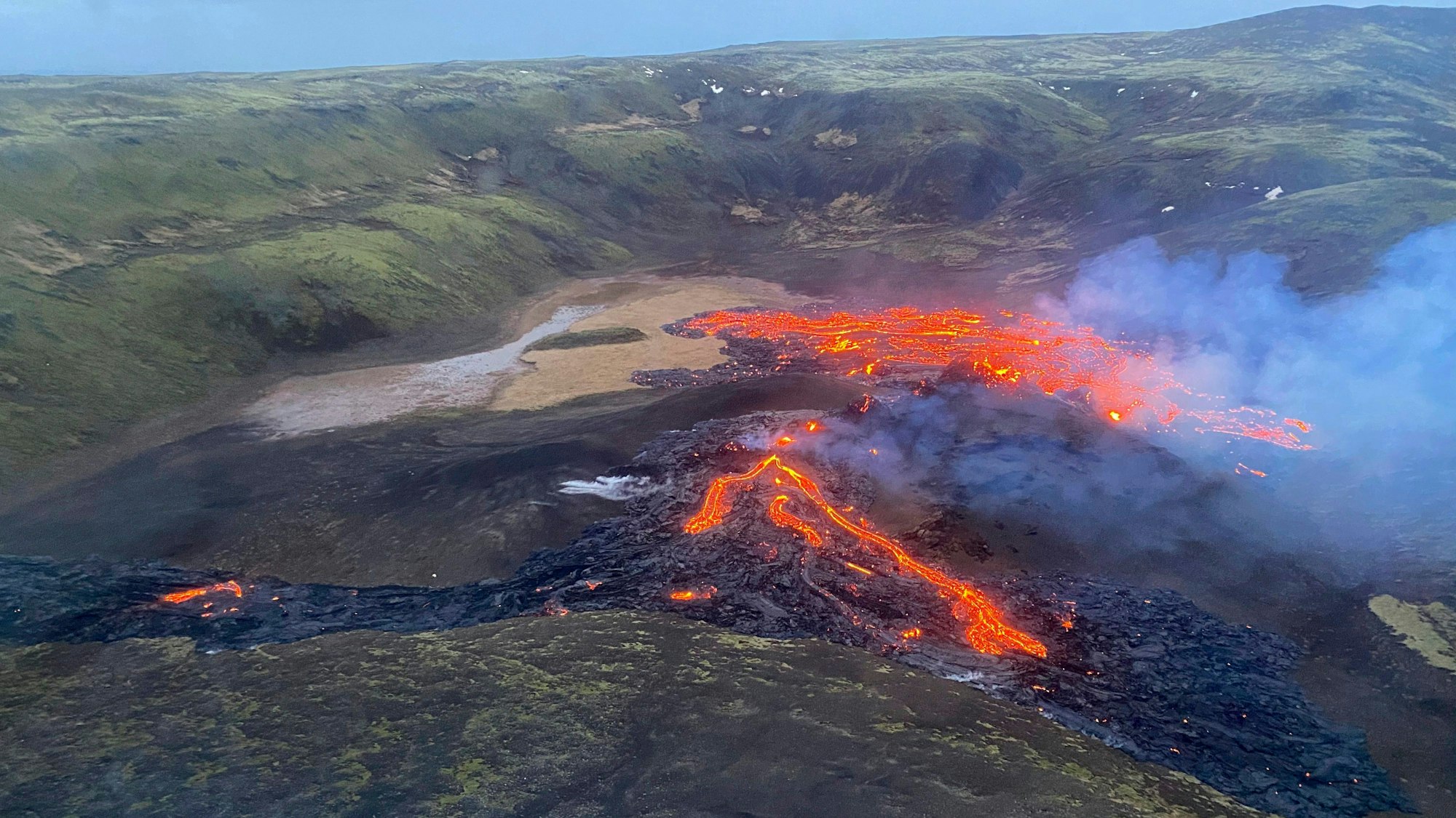 Eine Luftaufnahme der Küstenwache von 2021 zeigt, wie Lava aus dem Vulkan Fagradalsfjall fließt und Rauch aufsteigt. Der Vulkan liegt unweit der isländischen Hauptstadt Reykjavik. (Archivbild)