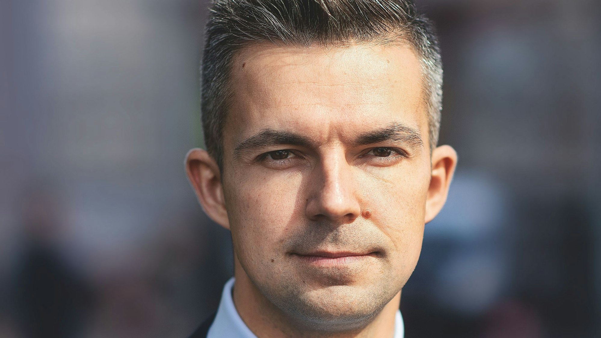 Nahaufnahme des Schriftstellers, er schaut in die Kamera. Er hat braune Augen und dunkle Haare,die bereits ergrauen.