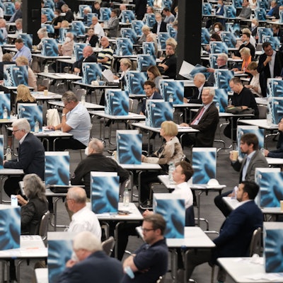 Das Bild zeigt die Kölner Messe von innen mit vielen tischen, hinter denen CDU-Mitglieder sitzen.