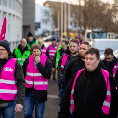 Eine Gruppe Streikender geht zum Bus, um damit nach Düren zu fahren.