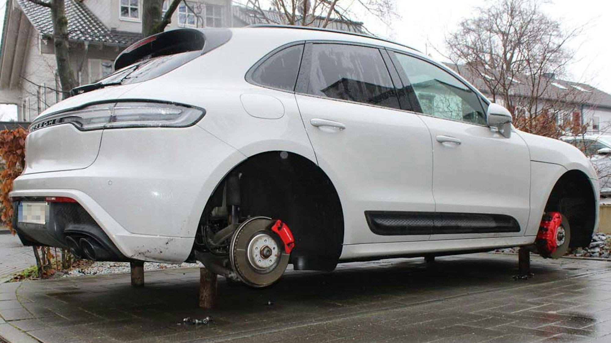 Ein weiter Porsche steht ohne Räder auf Holzblöcken aufgebockt.