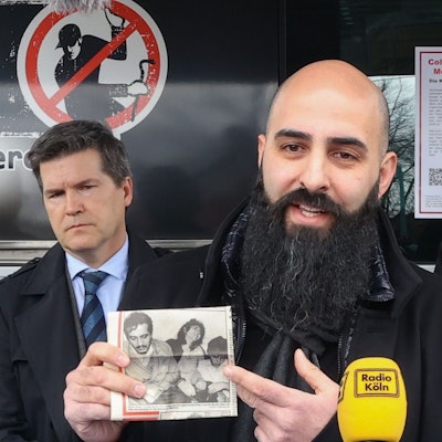 Basri Caglar, der Bruder der 1991 ermordeten Seckin, zeigt auf dem Poller Marktplatz einen alten Zeitungsartikel über die Tat – neben ihm Oberstaatsanwalt Ulrich Bremer (l.) und Hauptkommissar Markus Weber (r.).