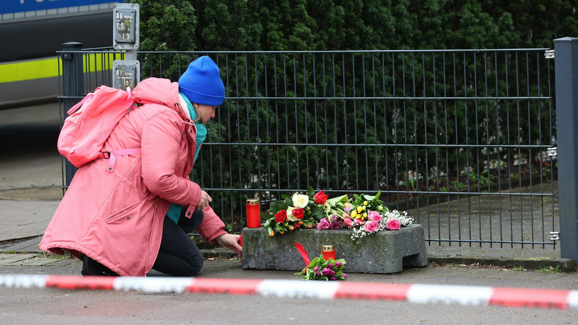 Eine Frau legt vor dem Gebäude der Zeugen Jehovas im Stadtteil Alsterdorf Blumen nieder.