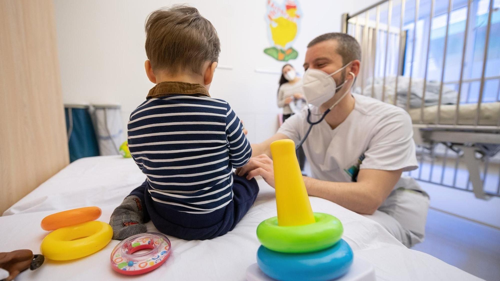 Ein Arzt untersucht in einer Kinderklinik ein Kind.