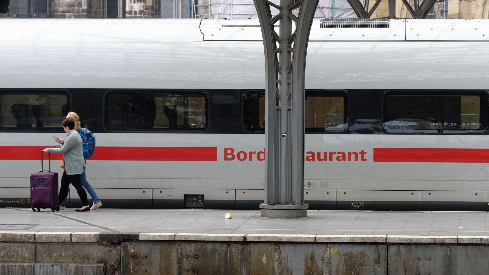 Reisende steigen auf einem Bahnsteig im Hauptbahnhof Köln in einen ICE der Deutschen Bahn ein.