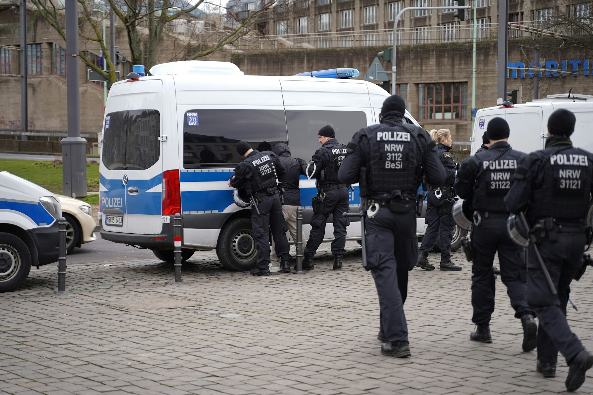 Polizeibeamte durchsuchen einen Teilnehmenden des Gegenprotests.