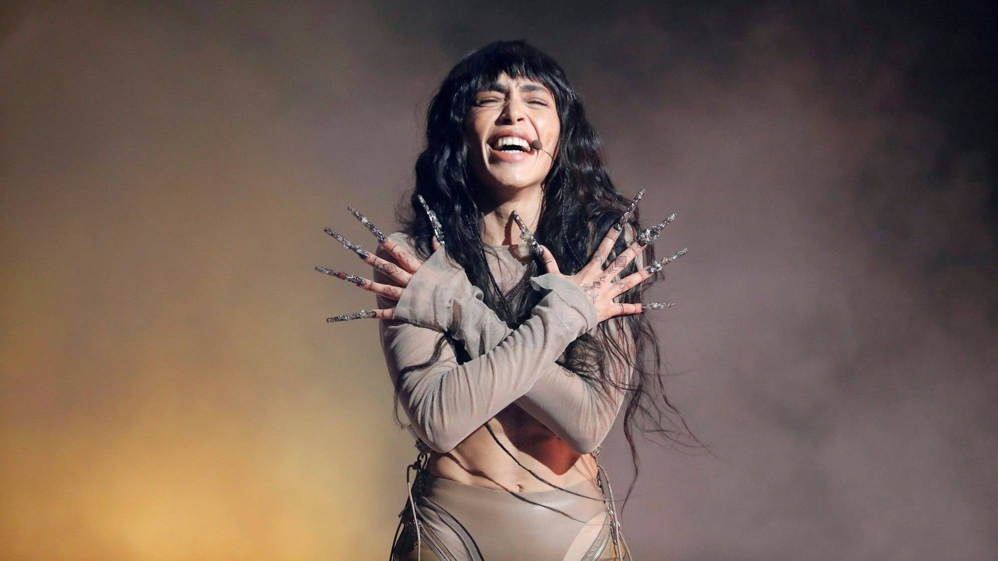 Loreen beim Auftritt mit geschlossenen Augen und ihren extralangen Fingernägeln. Sie hält die Hände über Kreuz.