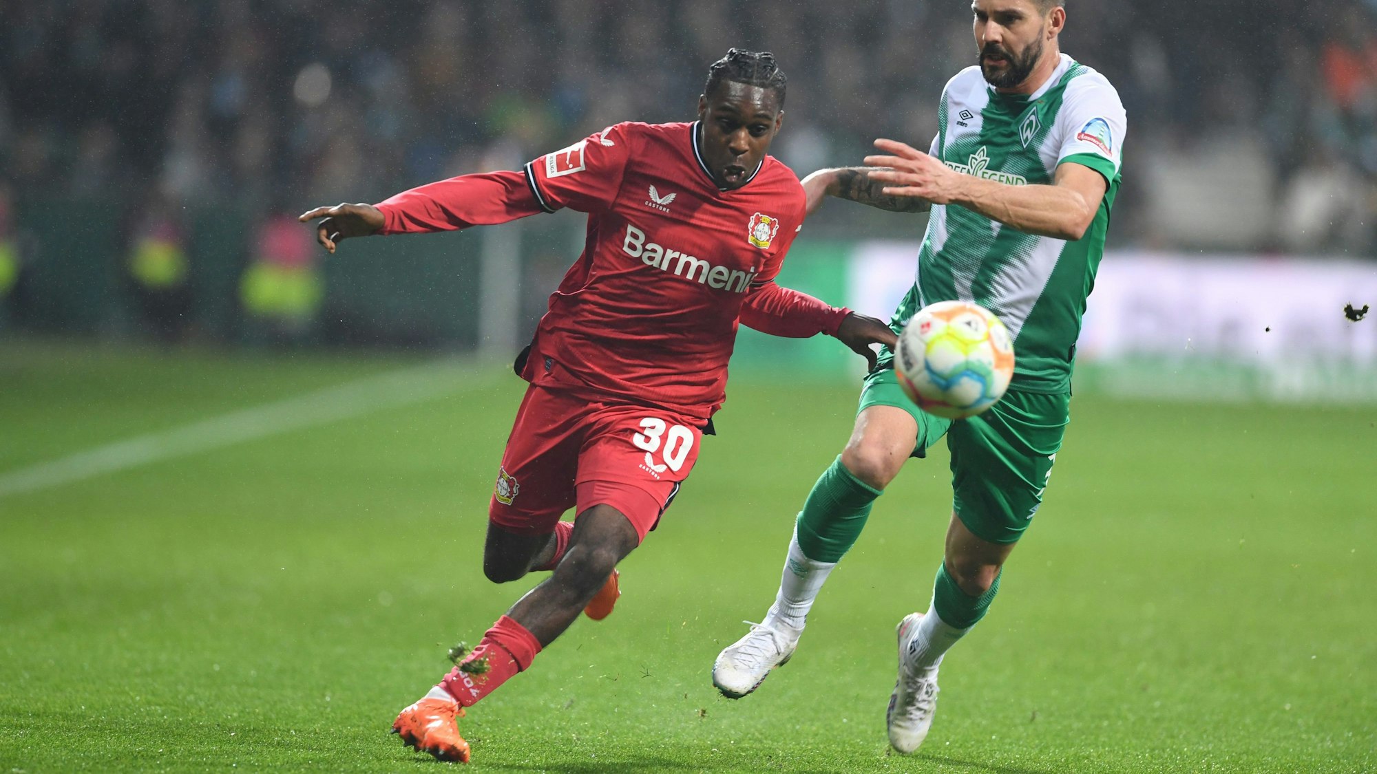 12.03.2023, Bremen: Fußball: Bundesliga, Werder Bremen - Bayer Leverkusen, 24. Spieltag, wohninvest Weserstadion. Werders Anthony Jung (r) kämpft gegen Leverkusens Jeremie Frimpong um den Ball. Foto: Carmen Jaspersen/dpa - WICHTIGER HINWEIS: Gemäß den Vorgaben der DFL Deutsche Fußball Liga bzw. des DFB Deutscher Fußball-Bund ist es untersagt, in dem Stadion und/oder vom Spiel angefertigte Fotoaufnahmen in Form von Sequenzbildern und/oder videoähnlichen Fotostrecken zu verwerten bzw. verwerten zu lassen. +++ dpa-Bildfunk +++