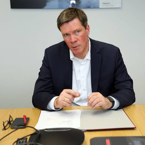 Stephan Santelmann, Landrat des Rheinisch-Bergischen Kreises, sitzt an einem Tisch.