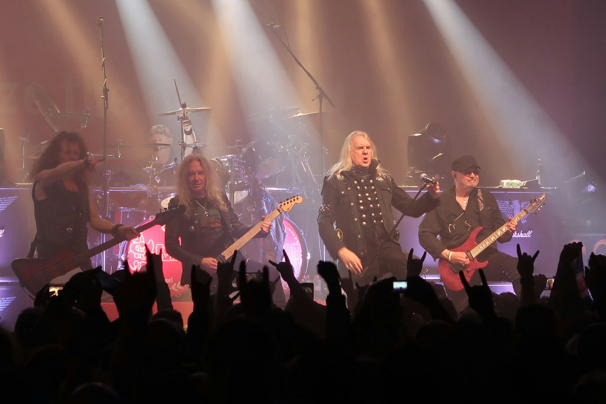 Die Musiker von Saxon stehen auf der Bühne in einer Reihe