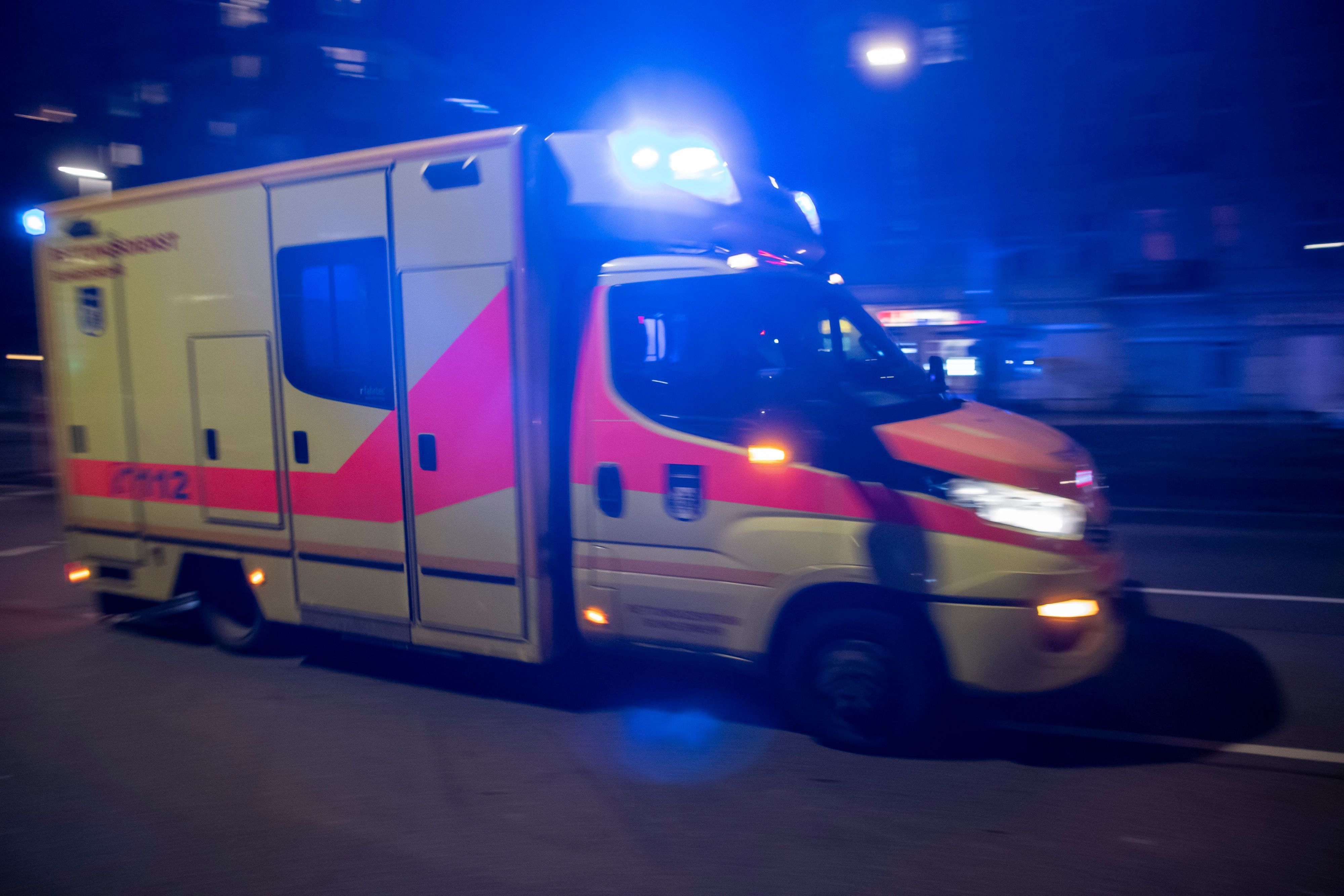Ein Rettungswagen fährt mit Blaulicht nachts durch Berlin.
