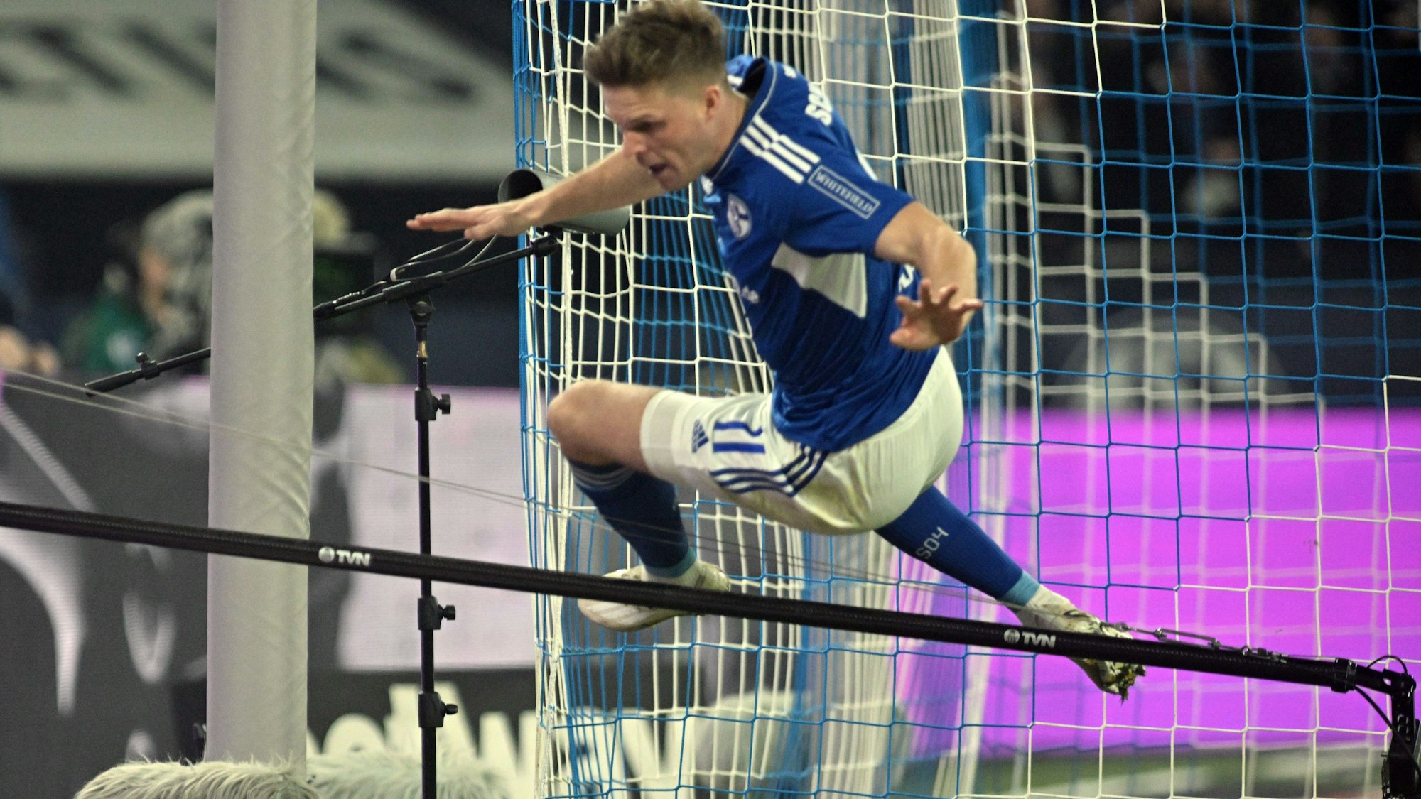 dpatopbilder - 11.03.2023, Nordrhein-Westfalen, Gelsenkirchen: Fußball: Bundesliga, FC Schalke 04 - Borussia Dortmund, 24. Spieltag, Veltins Arena. Marius Bülter von Schalke springt nach seinem Treffer zum 1:1 über eine Stange, an der eine bewegliche TV-Kamera befestigt ist. Foto: Bernd Thissen/dpa - WICHTIGER HINWEIS: Gemäß den Vorgaben der DFL Deutsche Fußball Liga bzw. des DFB Deutscher Fußball-Bund ist es untersagt, in dem Stadion und/oder vom Spiel angefertigte Fotoaufnahmen in Form von Sequenzbildern und/oder videoähnlichen Fotostrecken zu verwerten bzw. verwerten zu lassen. +++ dpa-Bildfunk +++