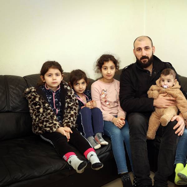 Saad, syrischer Familienvater, und seine fünf Kinder sitzen auf einem Sofa.