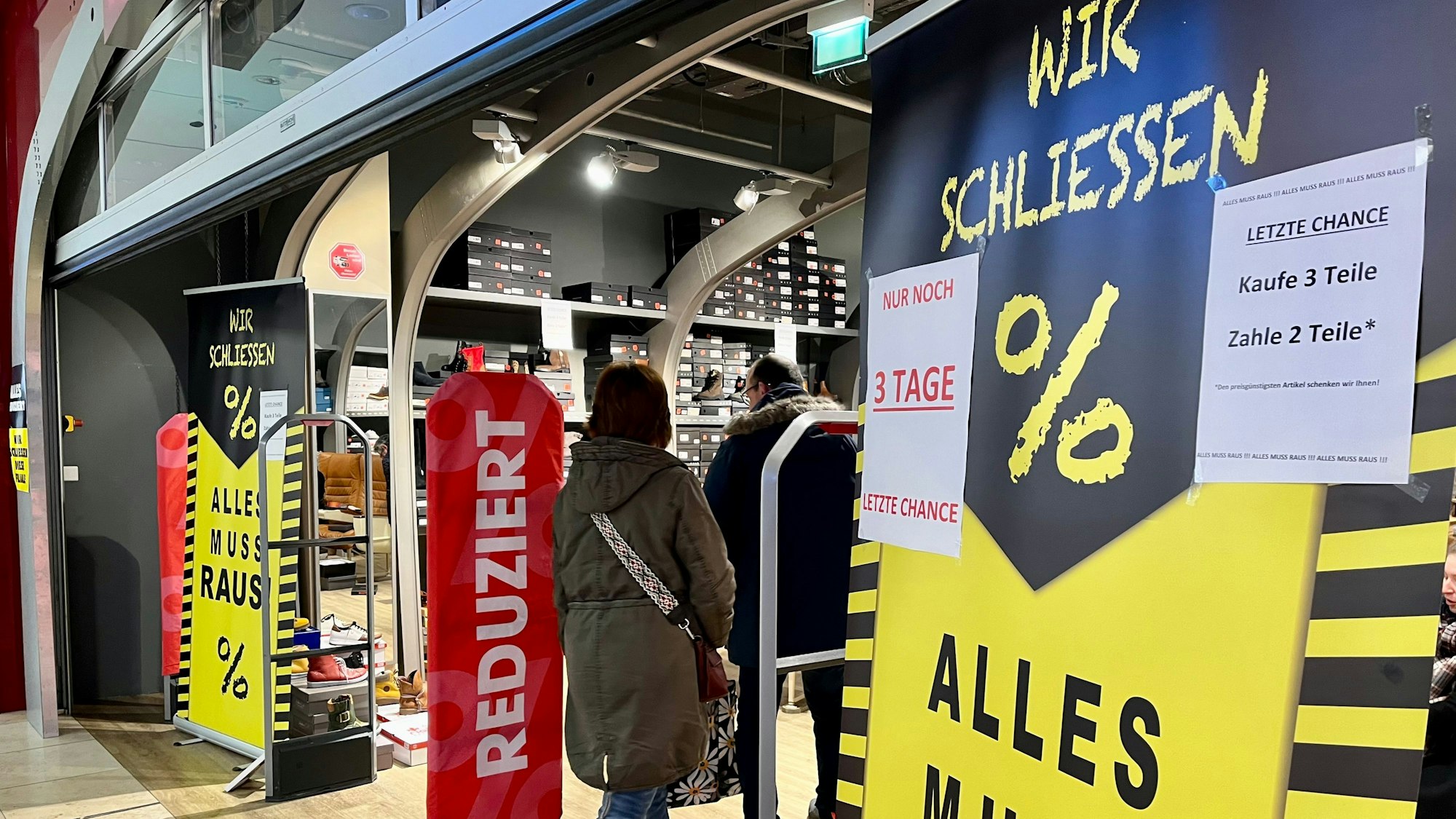 Alles-muss-raus-Schilder vor einem Schuhladen