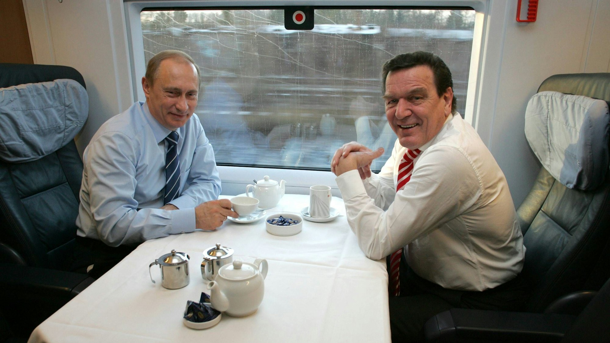 Alt-Bundeskanzler Gerhard Schroeder (r, SPD) und der russische Präsident Wladimir Putin bei einer gemeinsamen ICE-Fahrt von Hamburg nach Schleswig im Jahr 2004.