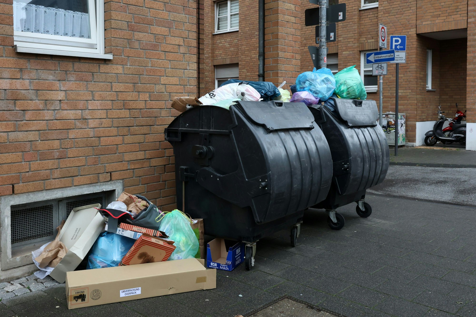 Ungeleerte Mülltonnen und Müllreste in der Stadt.