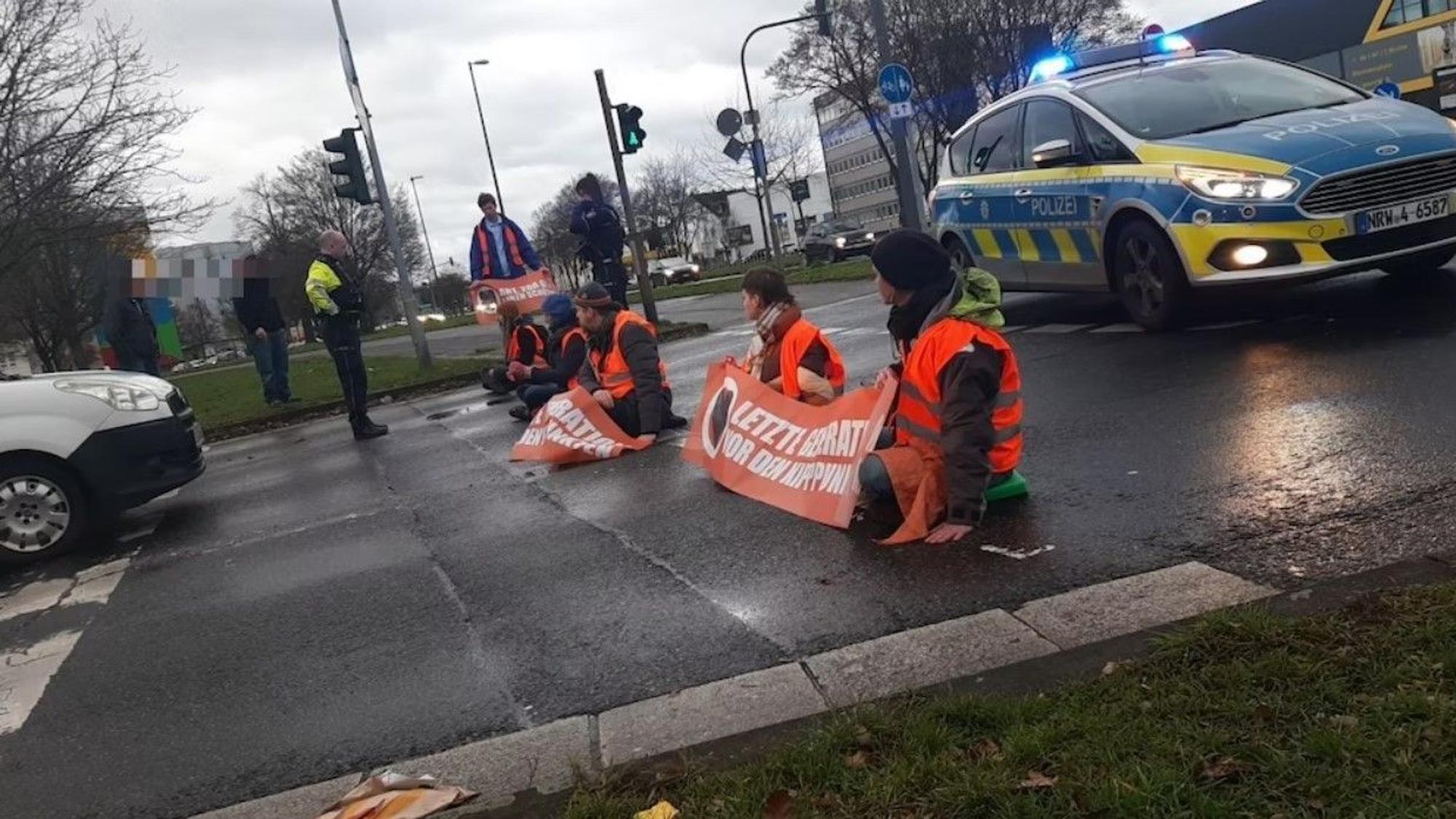 Mehrere Aktivisten haben sich am Montagfrüh auf die Fahrbahn in Köln-Mülheim geklebt.