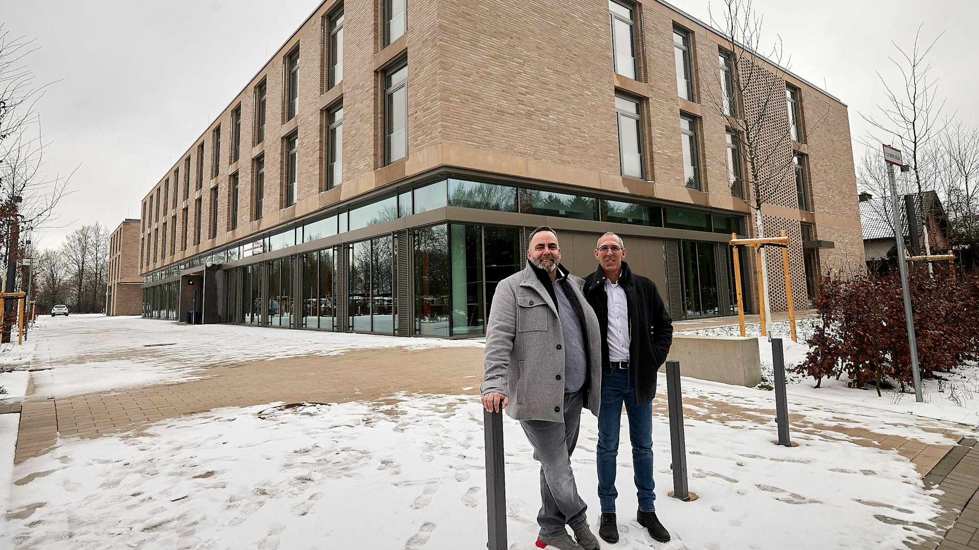 Zwei Männer stehen vor dem neuen Gästehaus des BGZ in Simmerath.