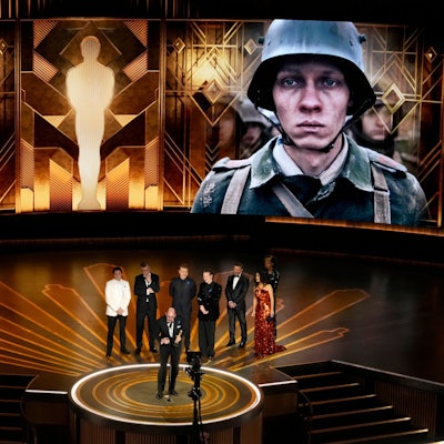 Regisseur Edward Berger (vorne) nimmt den Preis für «Im Westen nichts Neues» aus Deutschland für den besten internationalen Spielfilm bei der Oscar-Vverleihung im Dolby Theatre in Los Angeles entgegen. Hinten stehen Daniel Brühl (l-r), Malte Grunert, Albrecht Schuch, Felix Kammerer, Antonio Banderas und Salma Hayek.