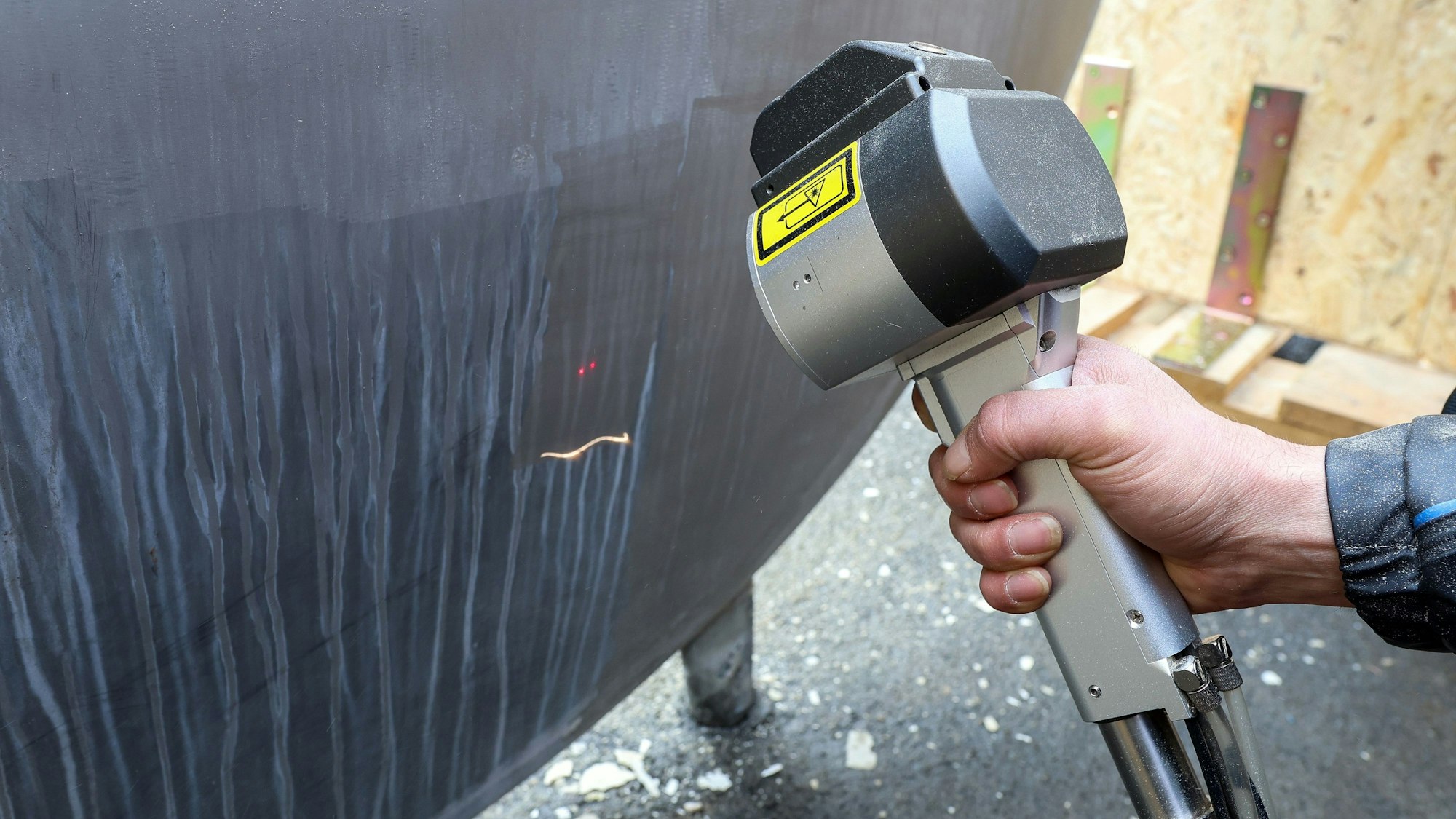 Ein Laser säubert die Oberfläche einer Wasseranlage.