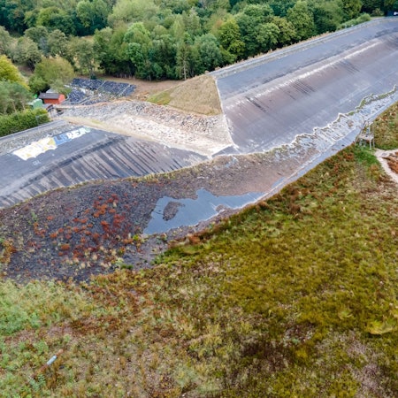 Die Luftaufnahme zeigt den Damm der Steinbachtalsperre bei Kirchheim. In der Mitte ist eine große Scharte zu sehen.