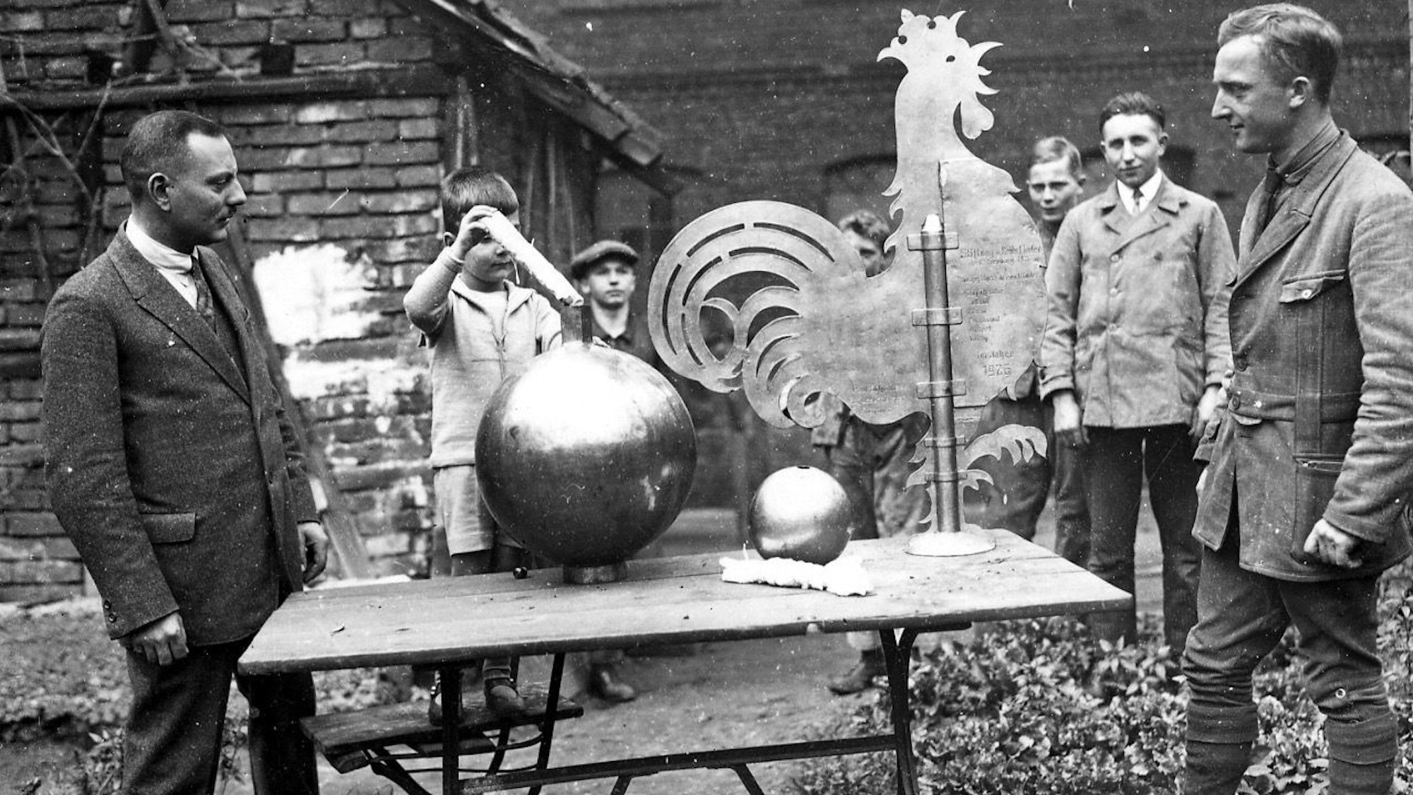 Foto von 1930: Der sechs oder sieben Jahre alte Josef Schneider steckt bei der Segnung des Wetterhahns eine Papierrolle in die Kapsel.