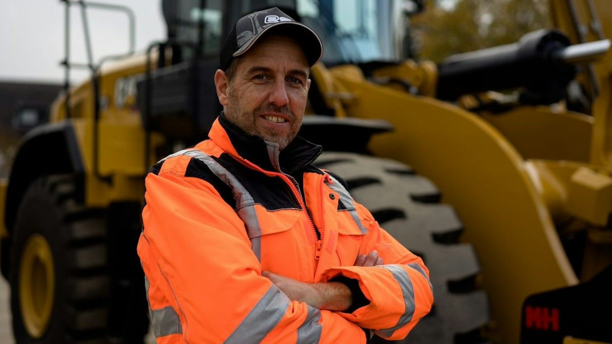 Sebastian Behr trägt eine Warnweste lächelt in die Kamera.