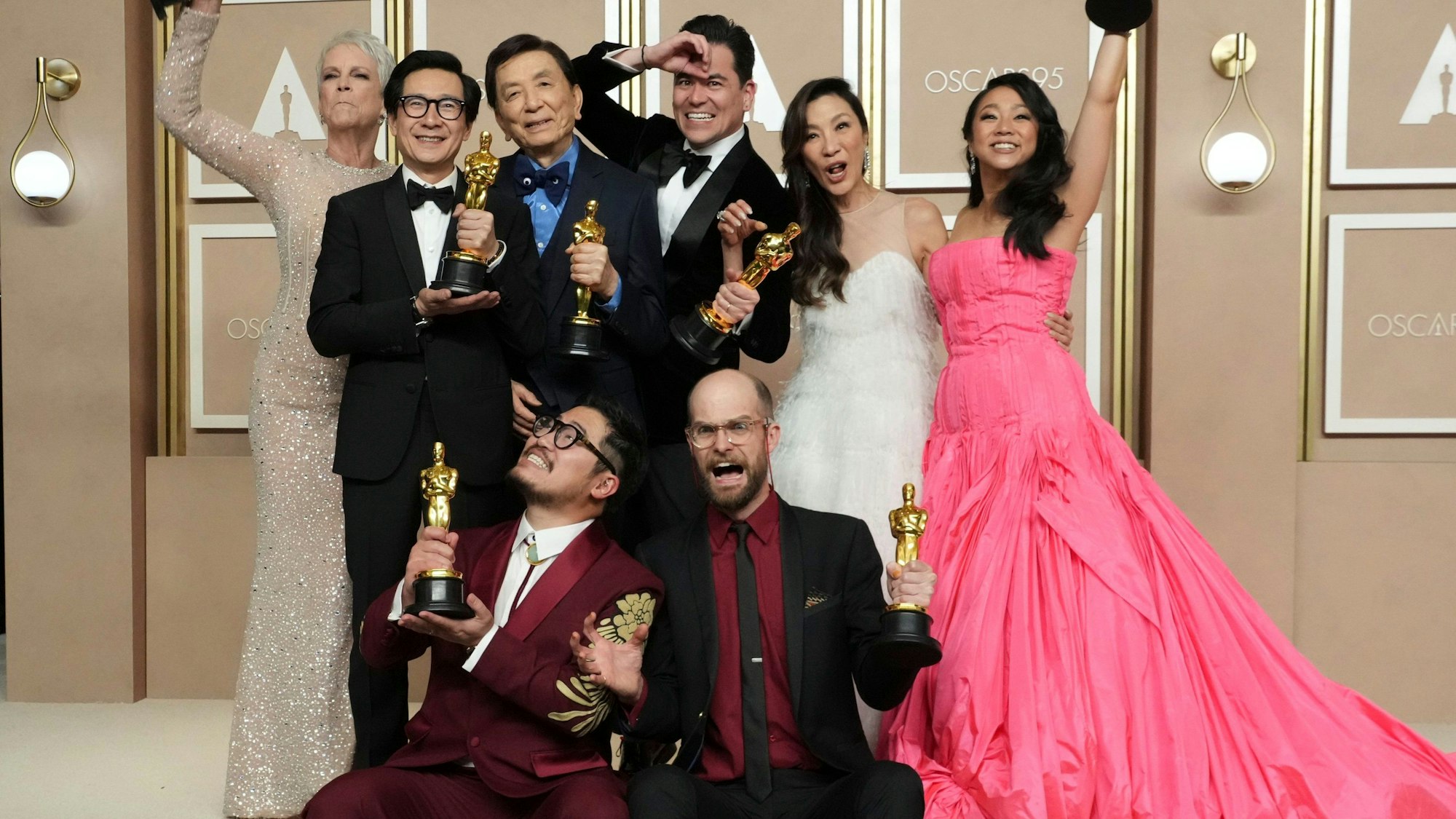 Jamie Lee Curtis (hinten l-r), Ke Huy Quan, James Hong, Jonathan Wang, Michelle Yeoh und Stephanie Hsu, Daniel Kwan (vorne l) und Daniel Scheinert, Gewinner des Oscars für den besten Film für «Everything Everywhere All at Once» posieren im Presseraum der Oscar-Verleihung im Dolby Theatre.