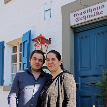 Dominik Eßer und Vera Brandt stehen vor ihrem Gasthaus Schwäle in Sand.