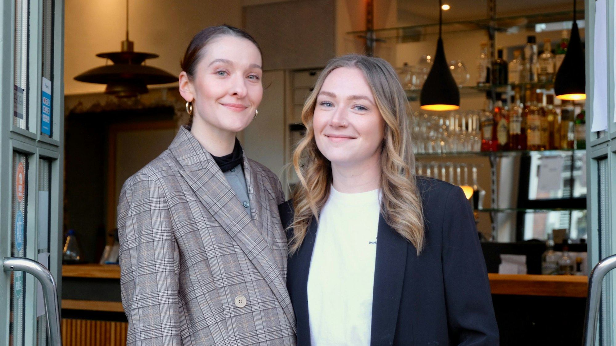 Zwei Frauen stehen in einem Türrahmen.