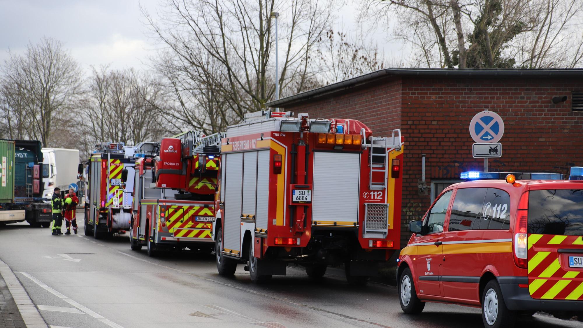 Einsatzfahrzeuge der Feuerwehr stehen aufgereiht an einer Straße.
