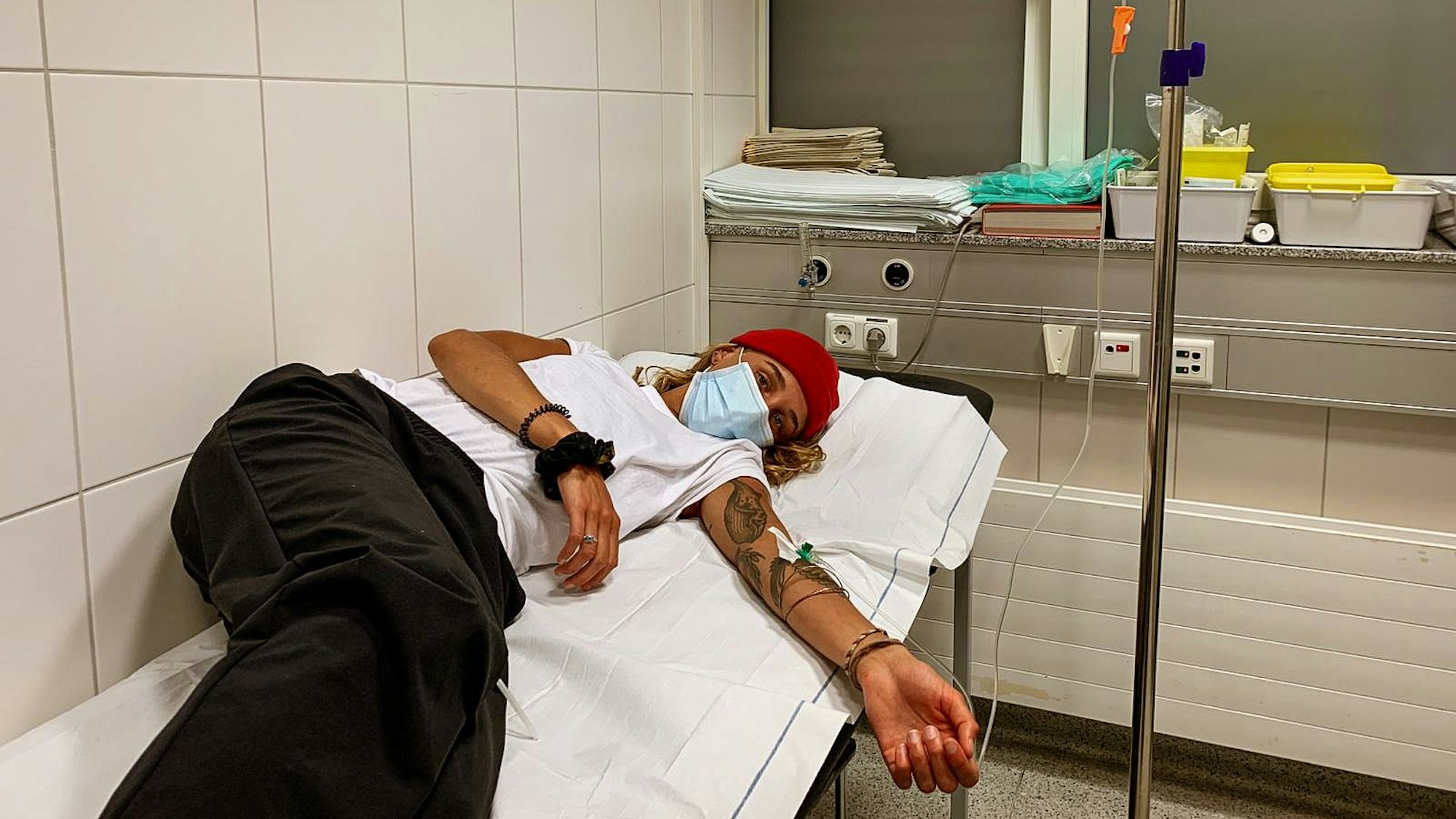 Elena Stiefelhagen liegt auf einer Liege im Krankenhaus und bekommt eine Infusion.