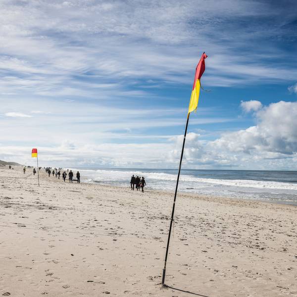 Spaziergänger gehen bei Sonnenschein am Brandenburger Strand spazieren.