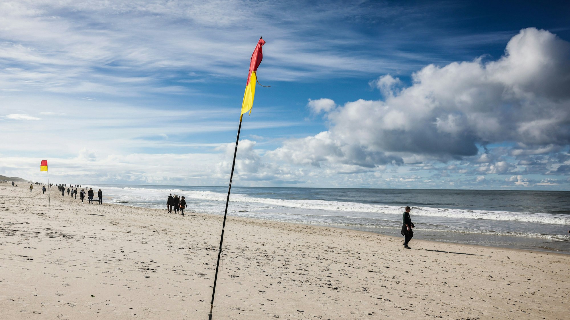 Spaziergänger gehen bei Sonnenschein am Brandenburger Strand spazieren.